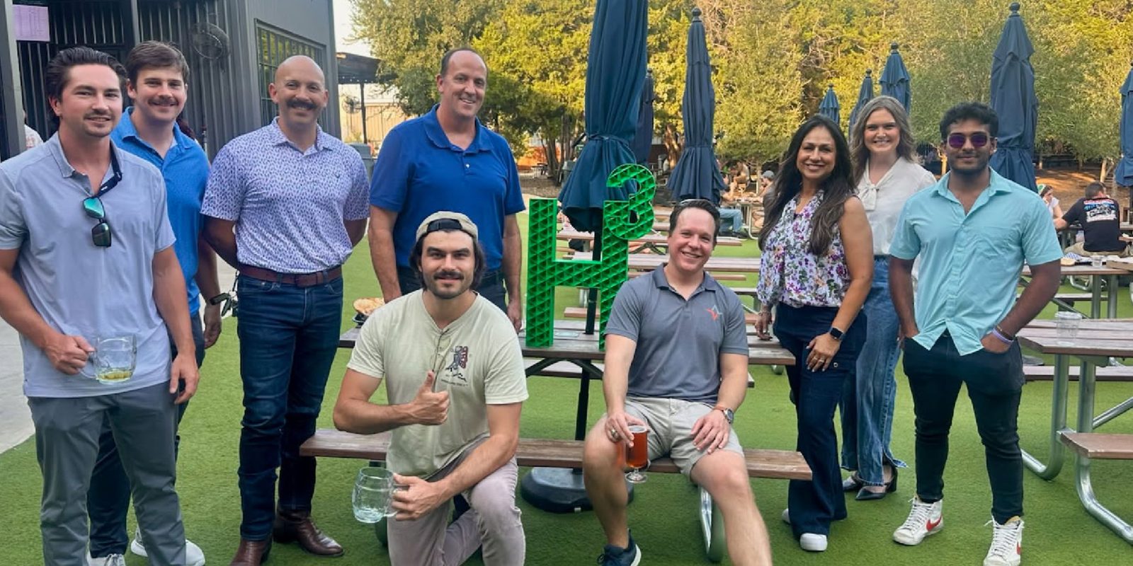 H³ ATX group photo outdoors with the H³ sign